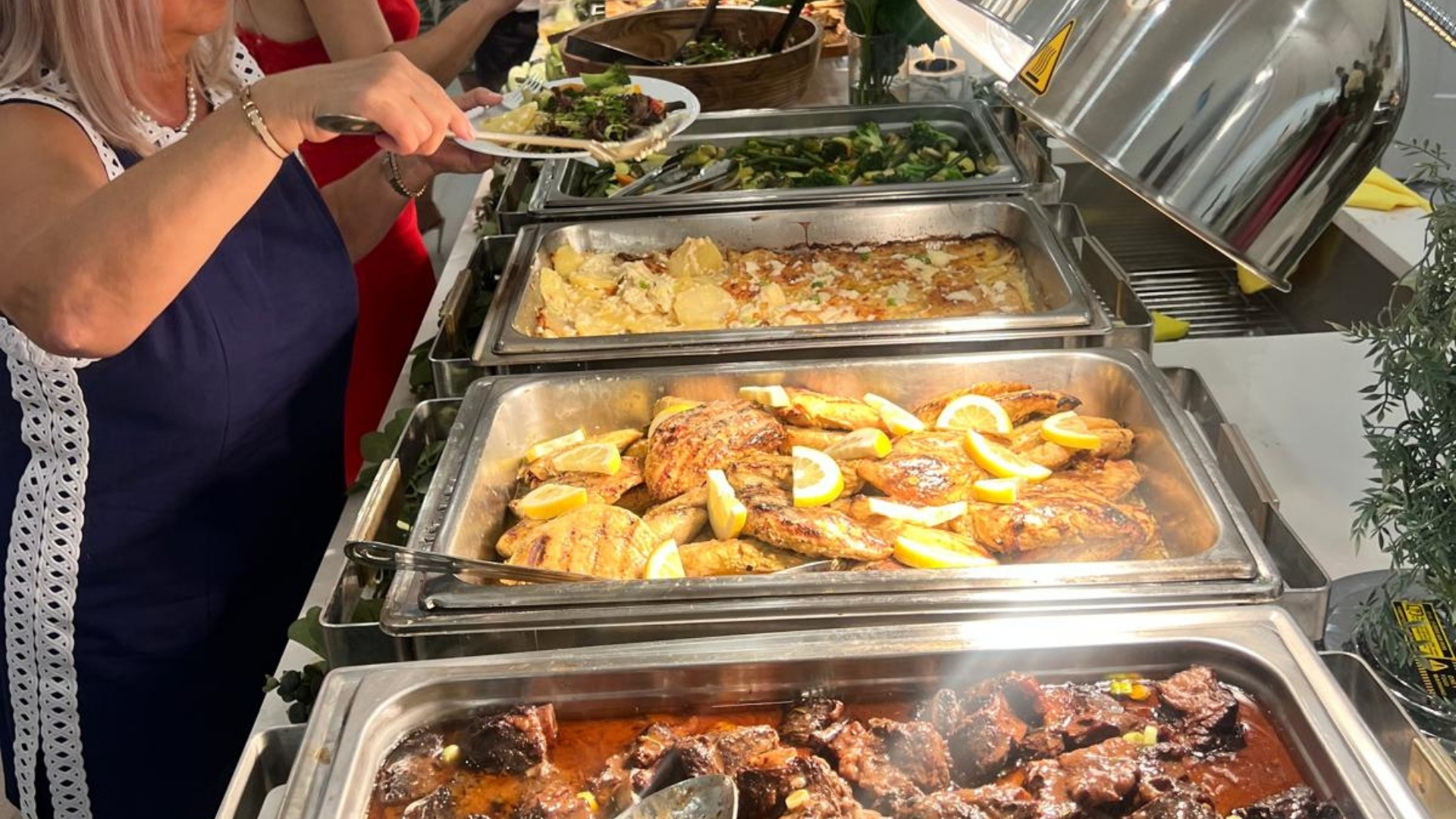 Elegant outdoor wedding setup with full-service catering team preparing beautifully plated gourmet dishes in Naples, Florida.