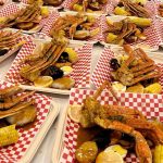 Elegant beach wedding reception setup with Creative Catering Naples signature dishes like seafood platters and carving stations, overlooking the Gulf of Mexico.
