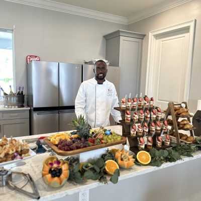 Chef Ricardo Lory preparing food behind a catering station for a client at a Creative Catering Naples event.